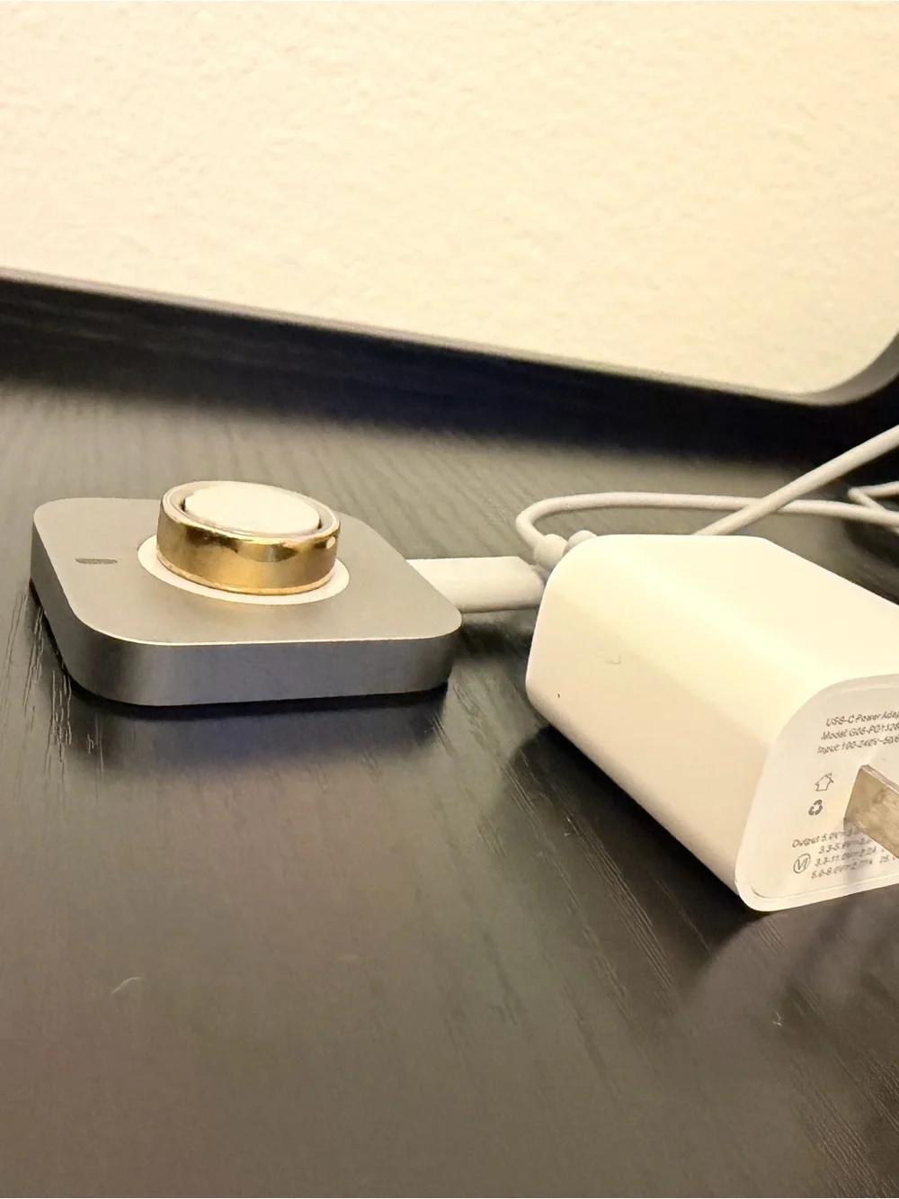 Oura Silver Charging Base with White Magnetic Puck and Gold Oura Ring 4
